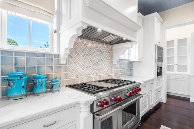 kitchen with double oven range, tasteful backsplash, custom exhaust hood, white cabinets, and dark hardwood / wood-style flooring