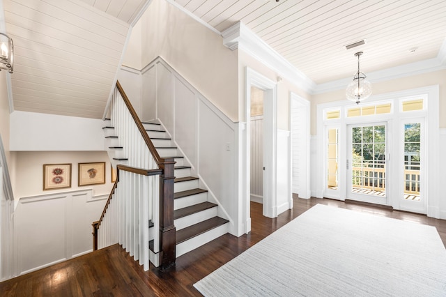 entryway featuring a chandelier, crown molding, and dark wood-type flooring