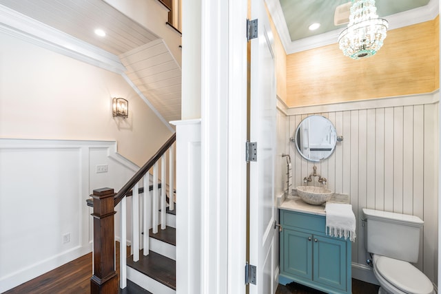 stairs featuring dark hardwood / wood-style flooring, crown molding, sink, and a chandelier