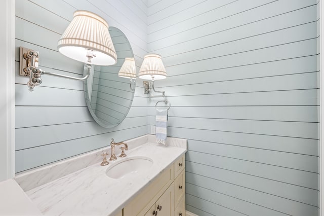 bathroom with wood walls and vanity