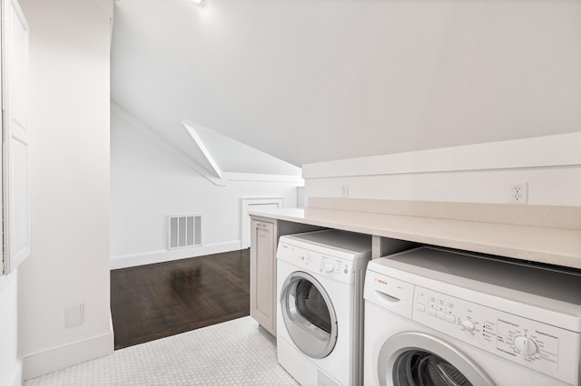 clothes washing area featuring light hardwood / wood-style flooring, cabinets, and separate washer and dryer