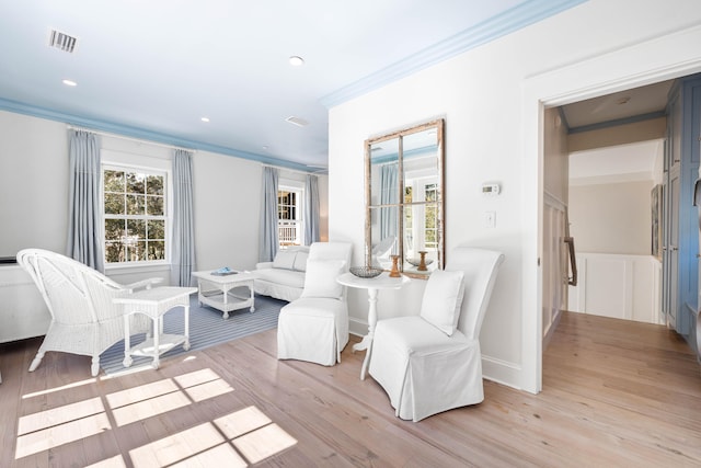 sitting room featuring light hardwood / wood-style floors and crown molding