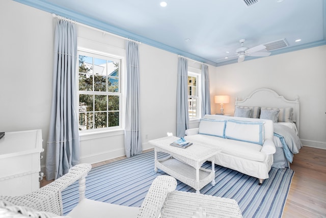 bedroom with multiple windows, ceiling fan, light wood-type flooring, and crown molding