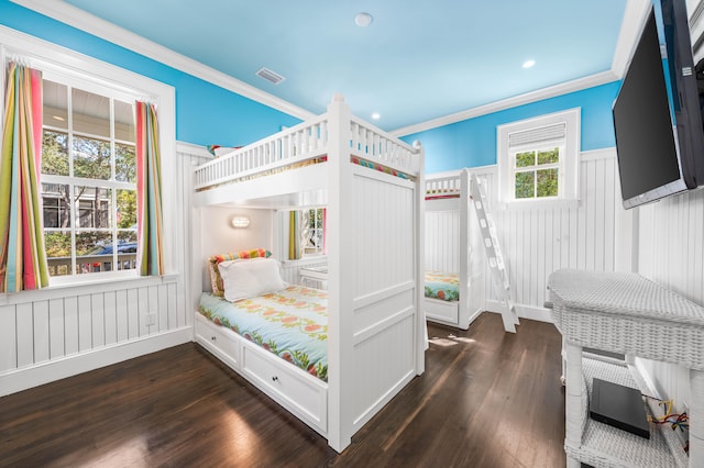 bedroom with ornamental molding and dark hardwood / wood-style floors