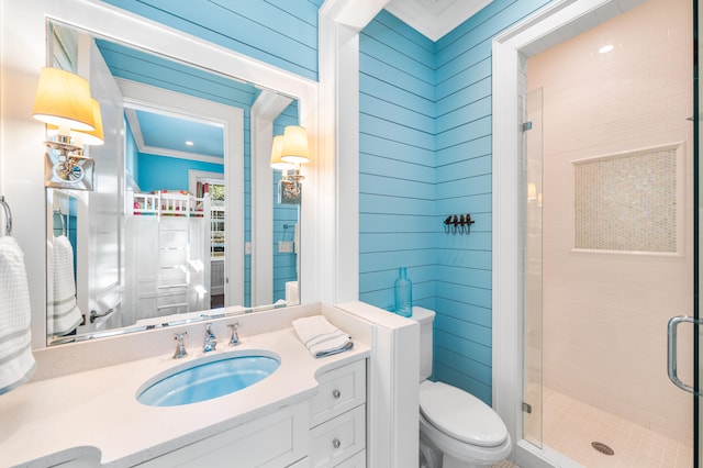 bathroom with a shower with door, vanity, crown molding, and toilet