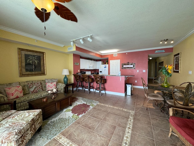 living room featuring rail lighting, tile patterned floors, and ornamental molding