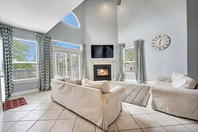 living room featuring french doors, a brick fireplace, a towering ceiling, light tile floors, and a textured ceiling