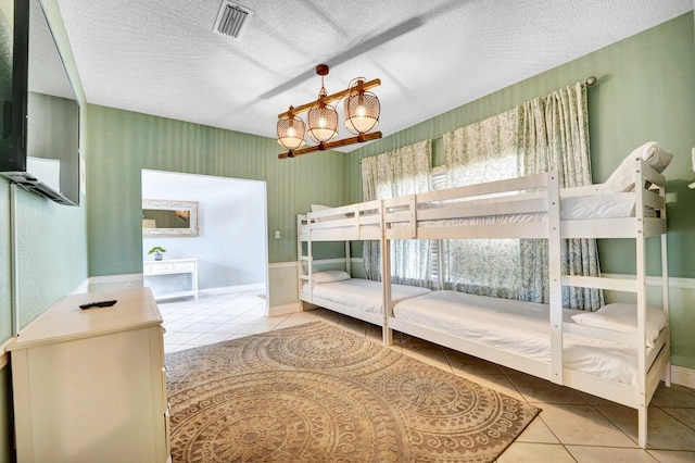 bedroom with a textured ceiling and light tile flooring