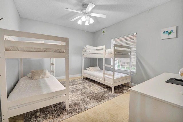 carpeted bedroom featuring a textured ceiling and ceiling fan