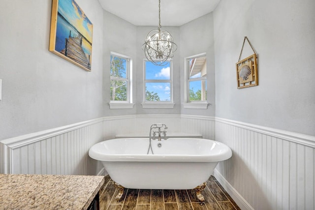 bathroom featuring a bathing tub, wood-type flooring, a chandelier, and vanity