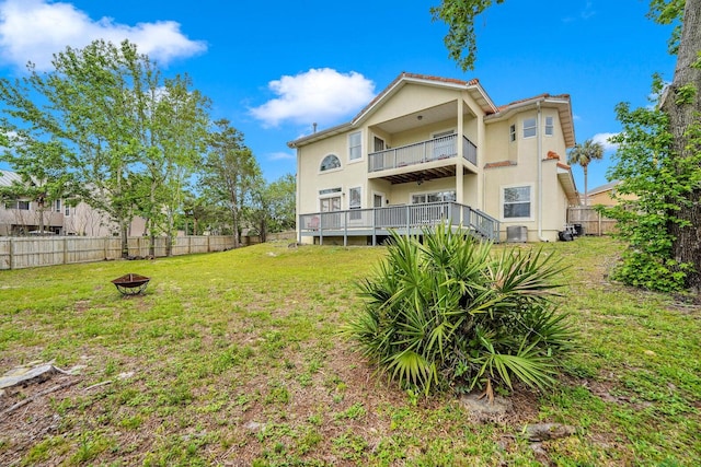 view of yard featuring an outdoor fire pit and a balcony