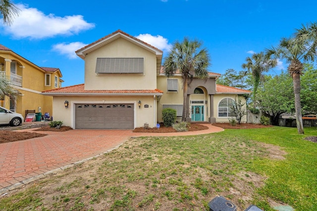 mediterranean / spanish-style house with a garage and a front lawn