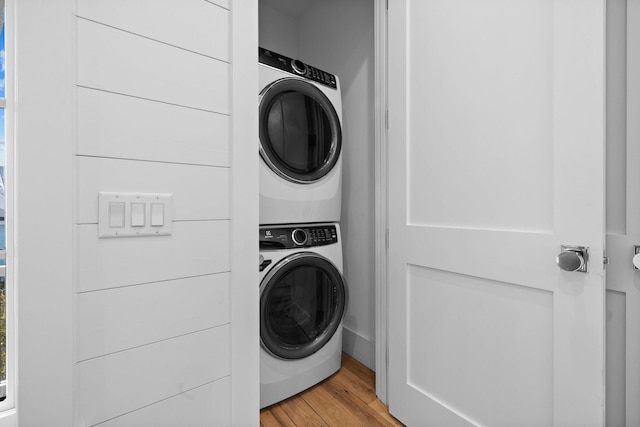 laundry area featuring light hardwood / wood-style floors and stacked washer and dryer