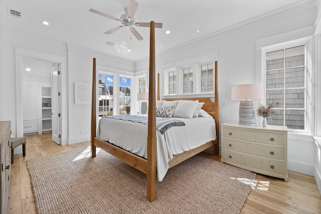 bedroom featuring ceiling fan, light hardwood / wood-style floors, and crown molding