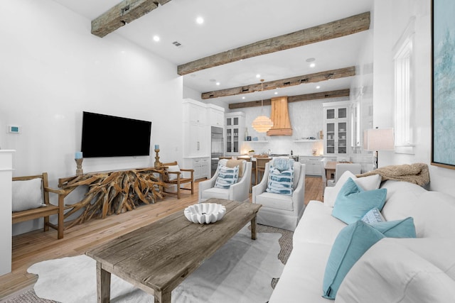 living room featuring light hardwood / wood-style flooring and beamed ceiling