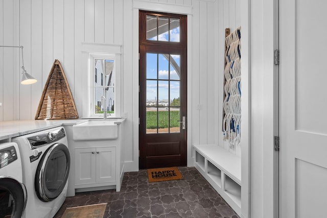 washroom featuring dark tile floors, independent washer and dryer, a healthy amount of sunlight, and sink