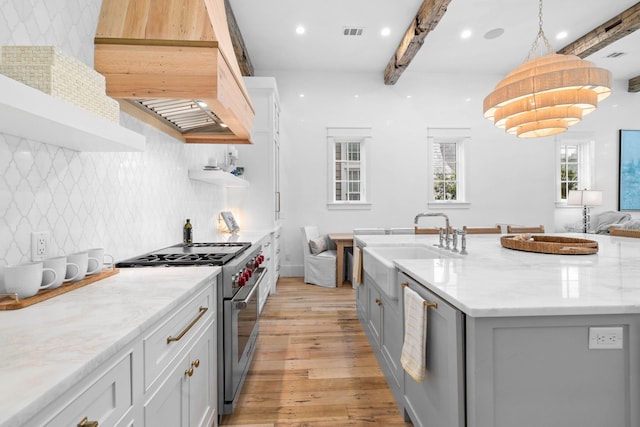 kitchen with backsplash, stainless steel appliances, beamed ceiling, and hanging light fixtures