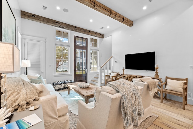 living room with beamed ceiling and light hardwood / wood-style flooring