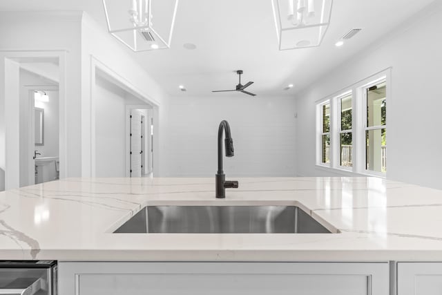 kitchen with beverage cooler, sink, light stone counters, and white cabinets