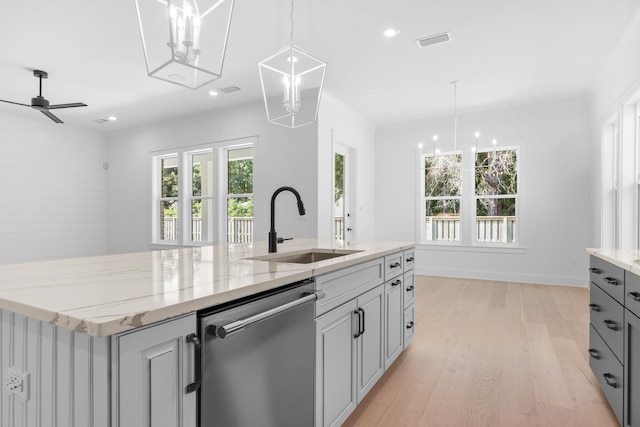 kitchen featuring dishwasher, light stone counters, gray cabinets, and plenty of natural light