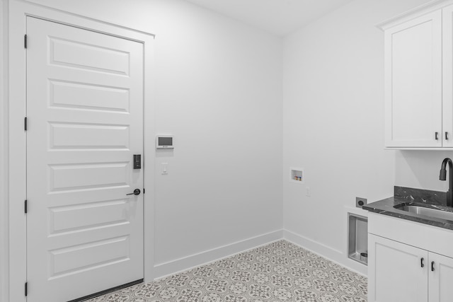 washroom with hookup for an electric dryer, hookup for a washing machine, cabinets, and sink