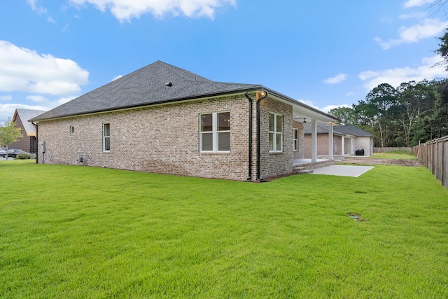 rear view of property featuring a patio area and a yard