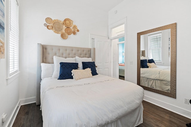 bedroom featuring multiple windows and dark hardwood / wood-style floors