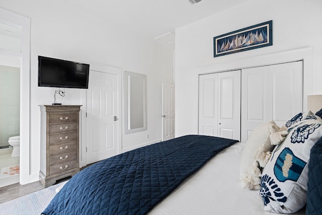 bedroom featuring hardwood / wood-style flooring, connected bathroom, and a closet