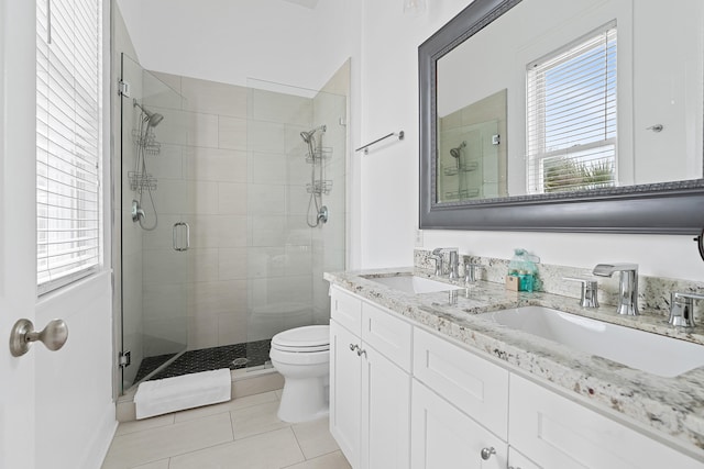 bathroom featuring a wealth of natural light, tile patterned flooring, a shower with door, and toilet