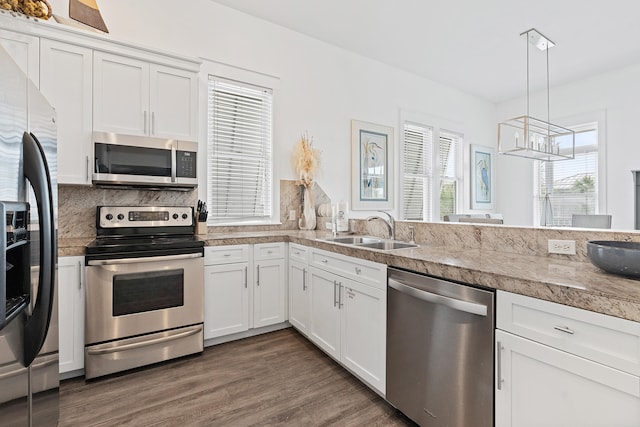 kitchen with white cabinets, decorative light fixtures, stainless steel appliances, and dark wood-type flooring