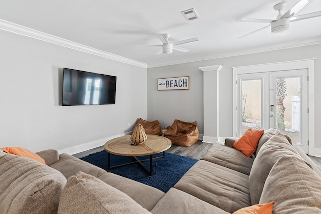 living room featuring hardwood / wood-style floors, ceiling fan, and crown molding