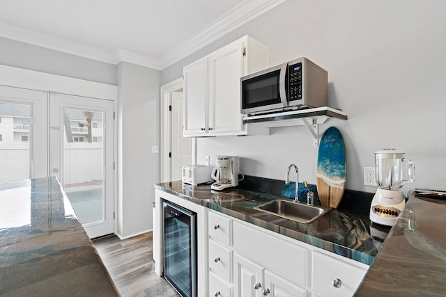 kitchen with wine cooler, crown molding, sink, light hardwood / wood-style floors, and white cabinetry