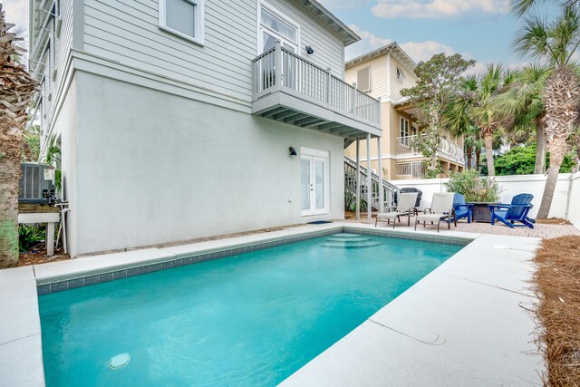 view of swimming pool with central air condition unit and a patio area