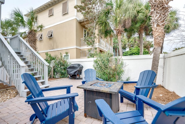 view of patio / terrace featuring area for grilling, a fire pit, and a wall unit AC