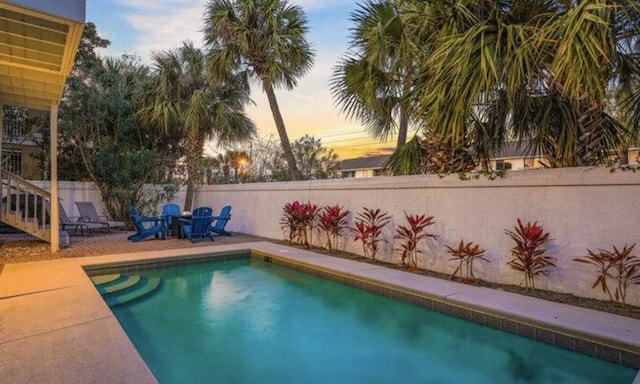 pool at dusk with a patio