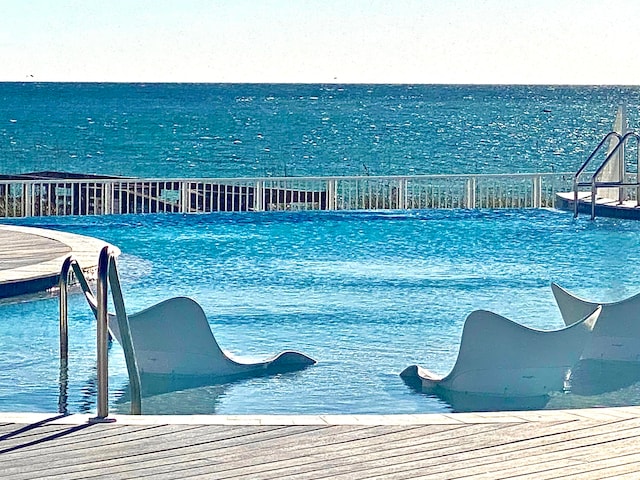 view of swimming pool featuring a water view