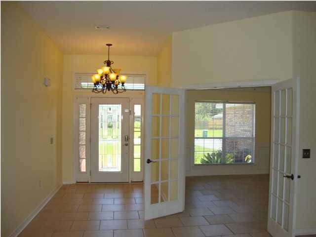 entrance foyer featuring french doors, tile patterned flooring, and a chandelier