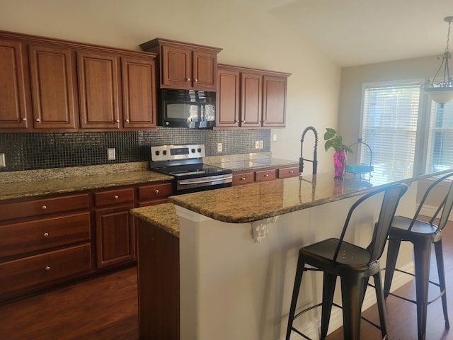 kitchen with decorative backsplash, dark hardwood / wood-style flooring, stainless steel range with electric cooktop, a breakfast bar area, and hanging light fixtures