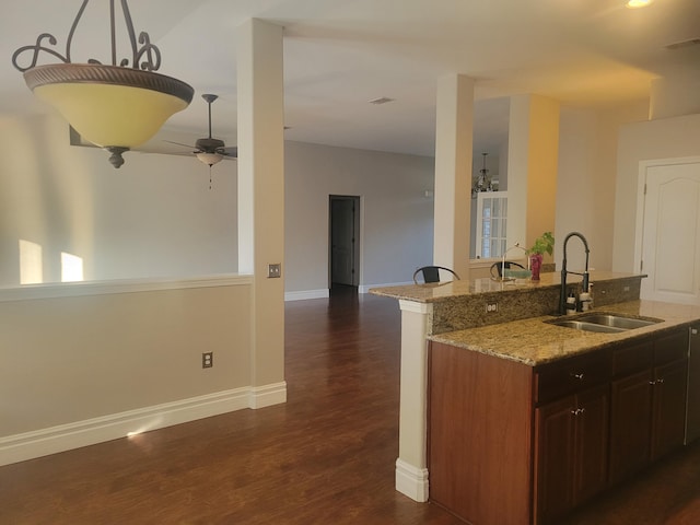 kitchen featuring sink, light stone counters, ceiling fan, and dark hardwood / wood-style floors