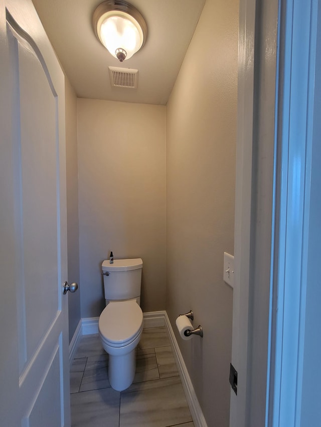 bathroom with toilet and tile patterned floors