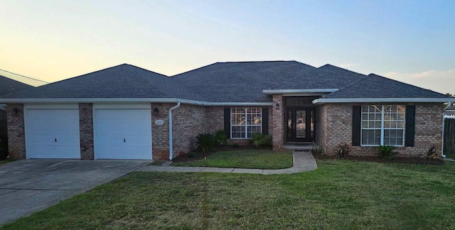 view of front of house with a yard and a garage