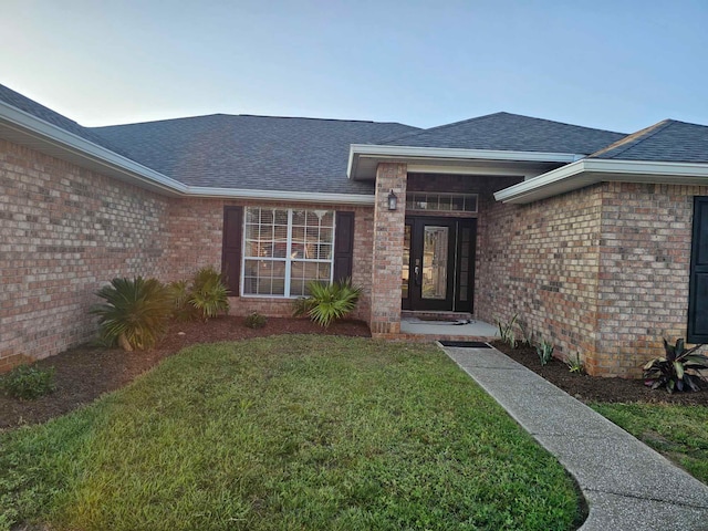 entrance to property featuring a lawn