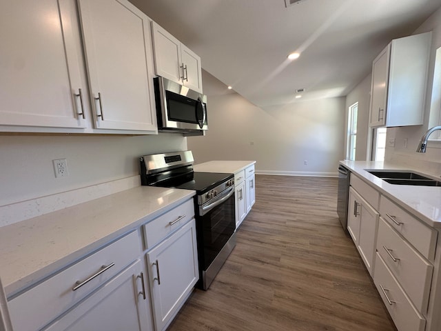 kitchen featuring white cabinetry, sink, dark wood-type flooring, and appliances with stainless steel finishes