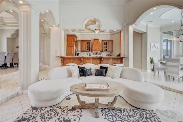 tiled living room featuring a notable chandelier, sink, and crown molding