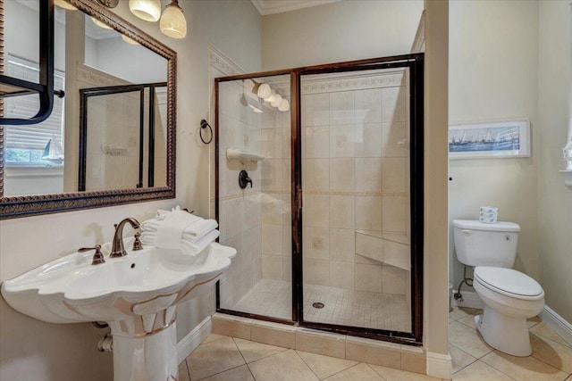 bathroom with toilet, tile patterned floors, and a shower with shower door