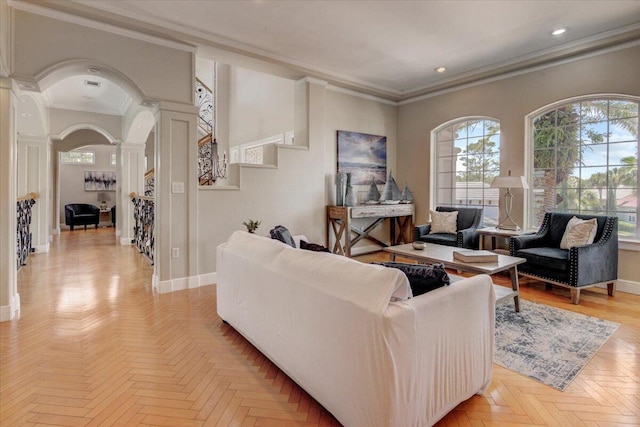 living room featuring decorative columns, light parquet flooring, and ornamental molding