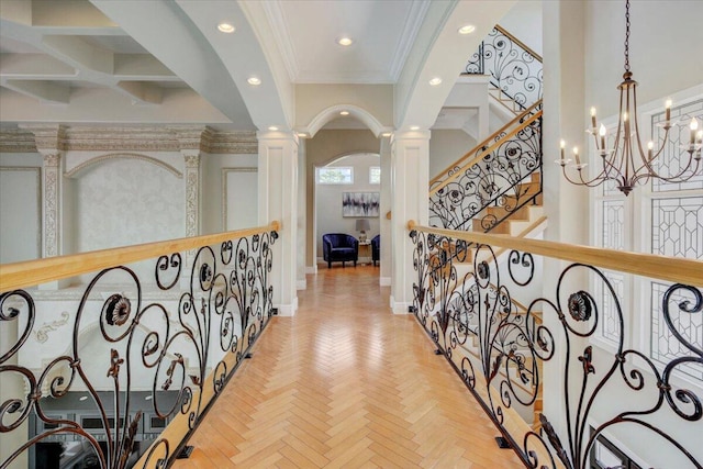 hall with ornate columns, light parquet floors, and crown molding