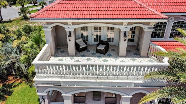 rear view of property featuring french doors and a balcony