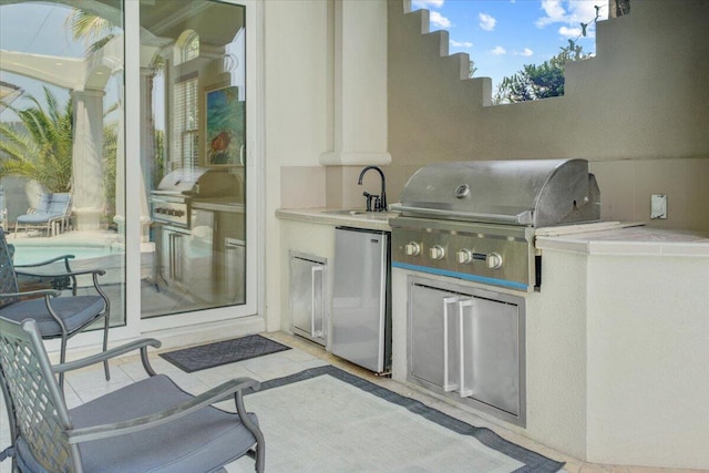 view of patio with area for grilling and sink