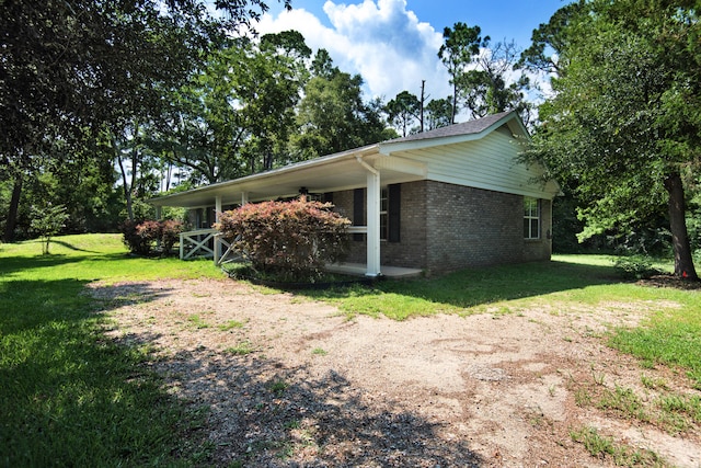 view of home's exterior with brick siding and a lawn